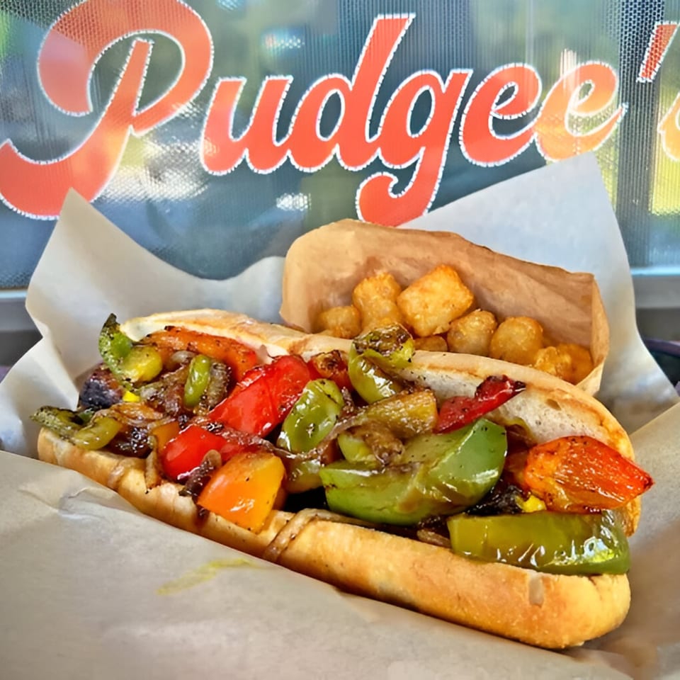 Pudgee's Eatery and Market's colorful cheesesteak with bell peppers and onions, served with tater tots.
